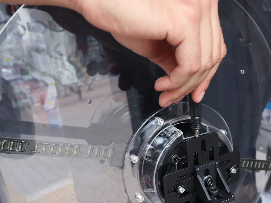A hand fastening the clear protective cover to the hologram