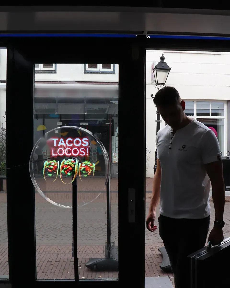 A hologram running in a shop doorway as the installer walks away